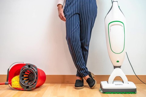 Woman prefers modern electric mop combined with vacuum cleaner than old bucket and mop