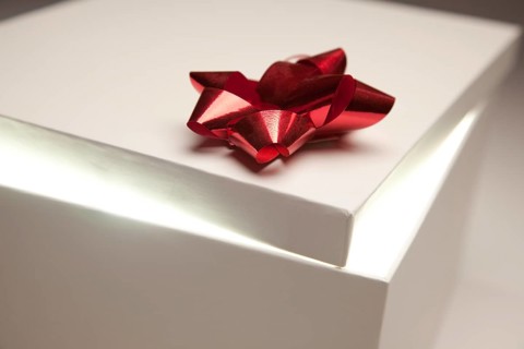 Gift box with red bow lid revealing very bright contents on a gradated background