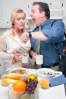 Late for work stressed couple checking time in kitchen