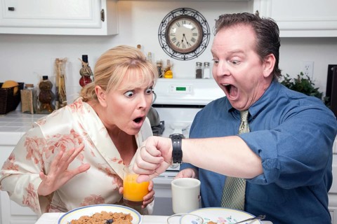 Late for work stressed couple checking time in kitchen