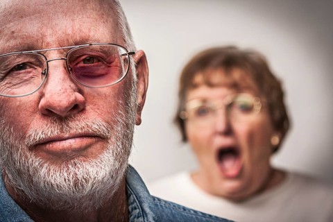 Battered and scared man with screaming angry woman behind