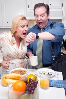 Late for work stressed couple checking time in kitchen