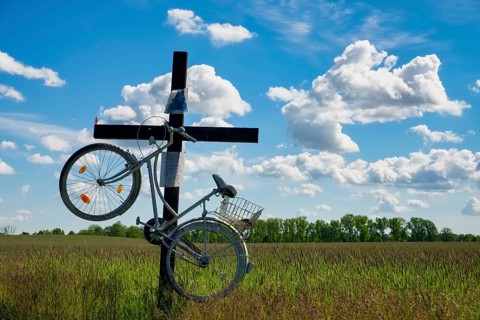 Cross with bicycle at country road near Trebbin