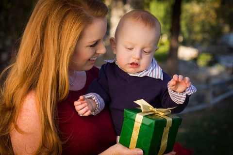 Beautiful young mother and smiling baby with wrapped christmas gift