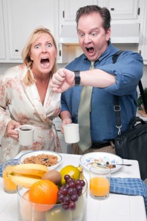 Late for work stressed couple checking time in kitchen
