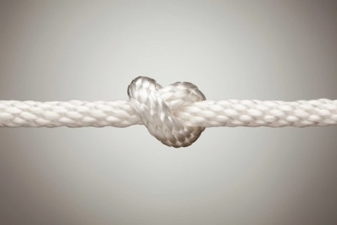 Nylon rope knot on a spot lit background