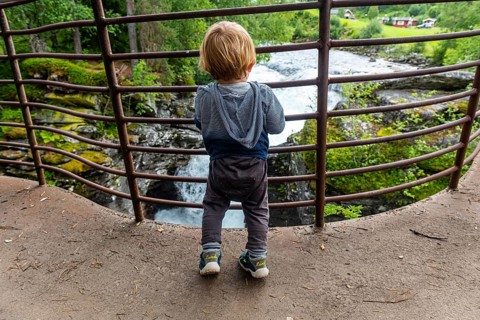 Boy looks at the rushing waters