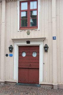 Traditional facade with red wooden door with ornaments decorations in red wooden house Swedish house in Vimmerby