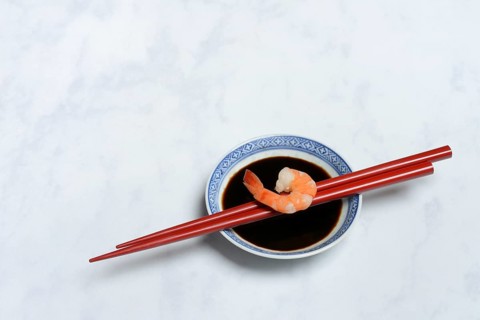 Cooked shrimp on chopsticks and shell with soy sauce
