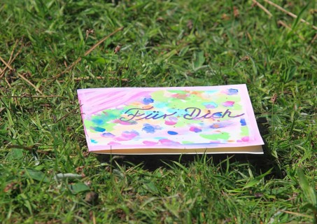 Self painted greeting card lies in a meadow
