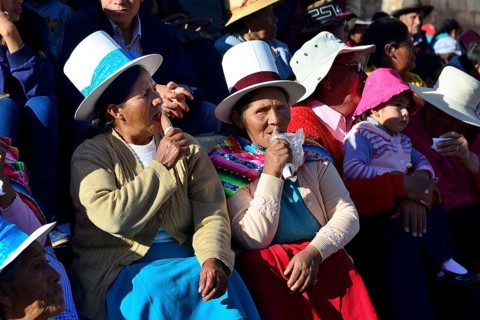 Two indigenous woman lapping up ice cream at the parade on the eve of Inti Raymi