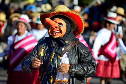 Mask of a man with a beer bottle at the parade on the eve of Inti Raymi