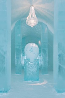 Long corridor with table and chandelier made of ice in the ice hotel of Jukkasjaervi