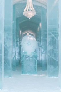 Long corridor with table and chandelier made of ice in the ice hotel of Jukkasjaervi