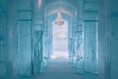 Long corridor with table and chandelier made of ice in the ice hotel of Jukkasjaervi
