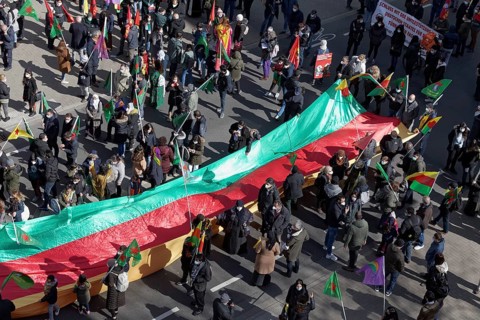 Protesters carry outstretched flag of the autonomous region of Kurdistan