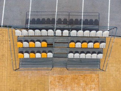Aerial view of small stands next to parking lot with seats for spectators at a fooball pitch in Altea La Vella