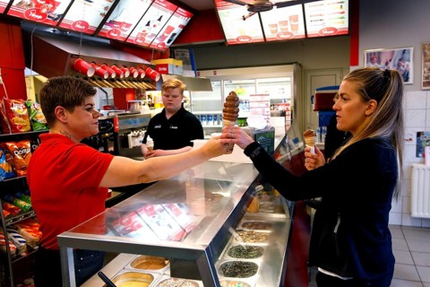 Ice cream vendor selling ice cream cone to customer