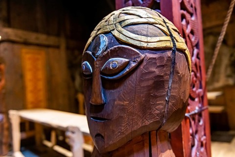 Wooden sculptures in a reconstructed long house in the Lofotr Viking Museum