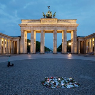 Brandenburg Gate with silent protest and parked e-scooter on Pariser Platz in the early morning