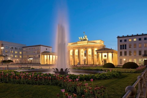 Illuminated Brandenburg Gate with fountain and Pariser Platz in the evening