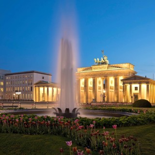 Illuminated Brandenburg Gate with fountain and Pariser Platz in the evening
