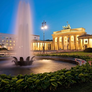 Illuminated Brandenburg Gate with fountain and Pariser Platz in the evening