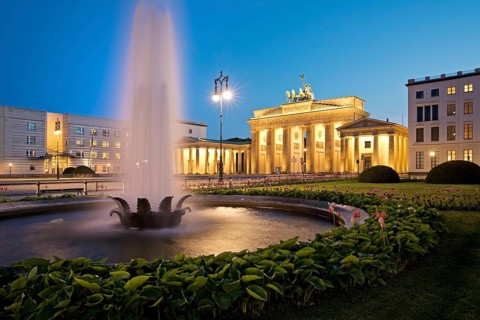 Illuminated Brandenburg Gate with fountain and Pariser Platz in the evening