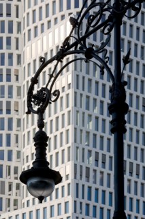 Old Berlin gas lantern in front of the modern high-rise Hotel Motel One Berlin-Upper West