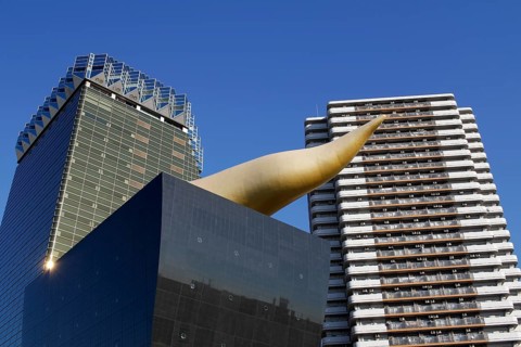Asahi Breweries headquarters building with the Asahi Flame by french designer Philippe Starck on the east bank of the Sumida River in Sumida district