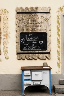 Advertising board and old stove in front of the soap manufactory Salzkontor in the UNESCO World Heritage Hallstatt at Lake Hallstatt