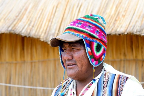 Man with colorful knitted cap on a floating island of the Uro