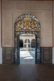 View through a door decorated with arabesques into the inner courtyard with fountain