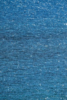 Sunbeams reflect glittering on the water surface of the Vierwaldstaettersee and form an abstract pattern