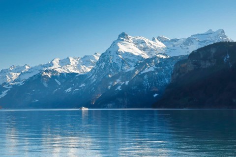 View from Brunnen on a boat on the Lake of Uri in front of the mountain scenery of the Alps of Uri