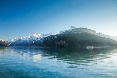 View from Brunnen on a boat on the Lake of Uri in front of the mountain scenery of the Alps of Uri