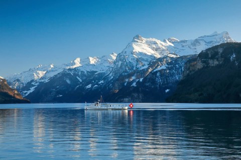 View from Brunnen on a boat on the Lake of Uri in front of the mountain scenery of the Alps of Uri