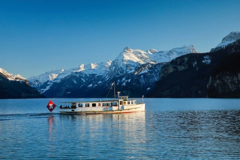 View from Brunnen on a boat on the Lake of Uri in front of the mountain scenery of the Alps of Uri