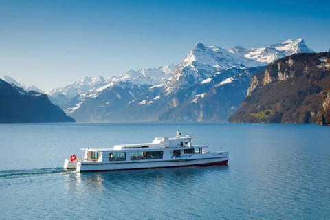 View from Brunnen on a boat on the Lake of Uri in front of the mountain scenery of the Alps of Uri
