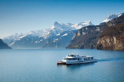 View from Brunnen on a boat on the Lake of Uri in front of the mountain scenery of the Alps of Uri