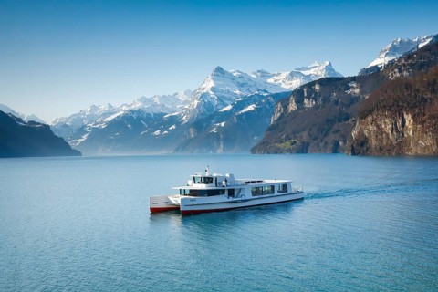 View from Brunnen on a boat on the Lake of Uri in front of the mountain scenery of the Alps of Uri