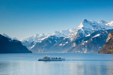 View from Brunnen on a boat on the Lake of Uri in front of the mountain scenery of the Alps of Uri