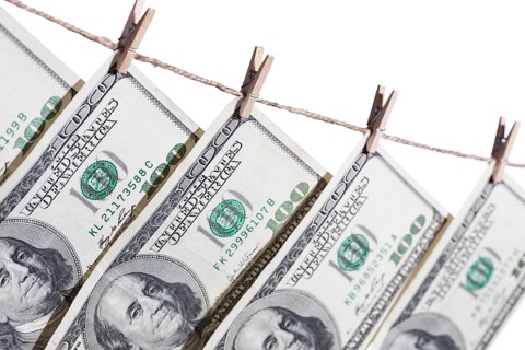 Hundred dollar bills hanging from clothesline on a white background
