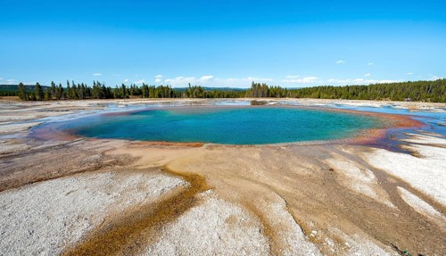 Steaming hot spring with colored mineral deposits