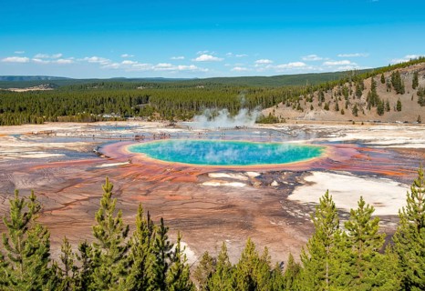 Steaming hot spring with colored mineral deposits and turquoise water