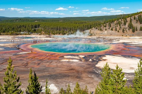 Steaming hot spring with colored mineral deposits and turquoise water