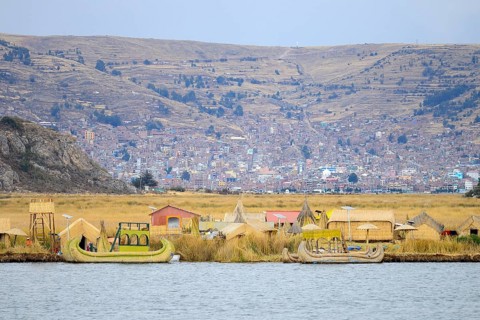 Floating island of the Uro with the city of Puno in the background