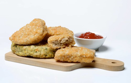 Meat substitute on wooden board and tray with ketchup
