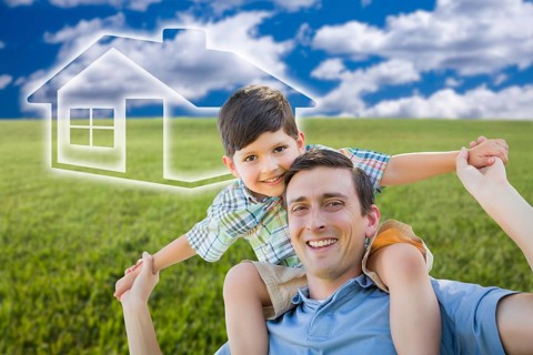 Excited mixed-race father and son piggyback over grass field