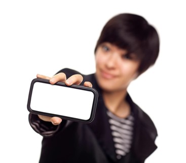 Smiling young mixed-race woman holding blank smart phone out